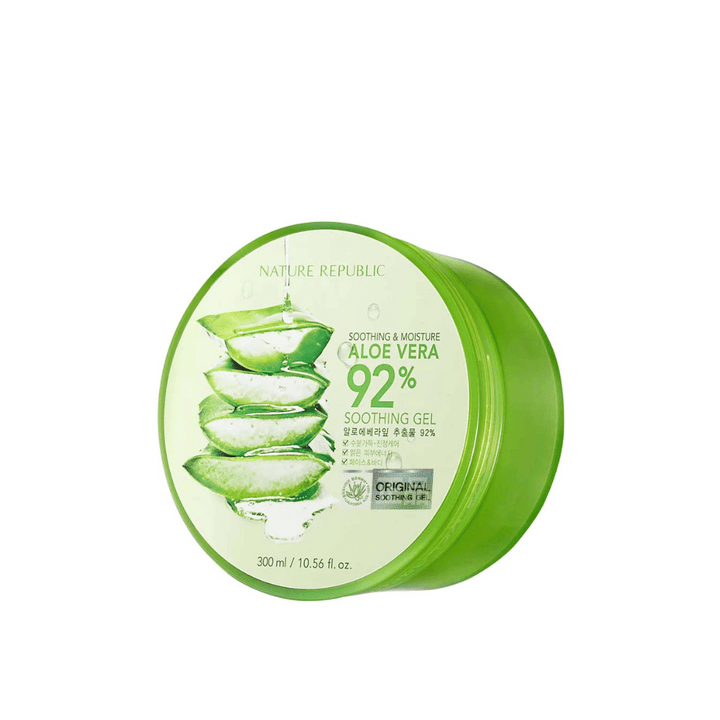 Zelena okrogla posoda z Nature Republic Aloe Vera 92% Soothing Gel. Embalaža prikazuje sliko aloe vera listov in besedilo, ki opisuje pomirjujoče in vlažilne lastnosti izdelka. Vsebina je 300 ml (10,56 fl. oz).