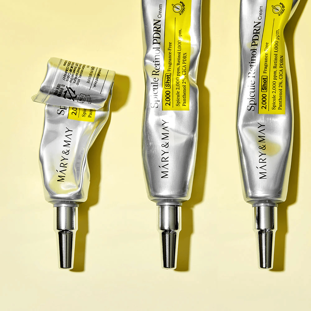 MARY & MAY Spicule Retinol PDRN Cream z vidno uporabo v tubi, prikazuje konsistenco kreme in usmerjen aplikator za natančno nanašanje na kožo.