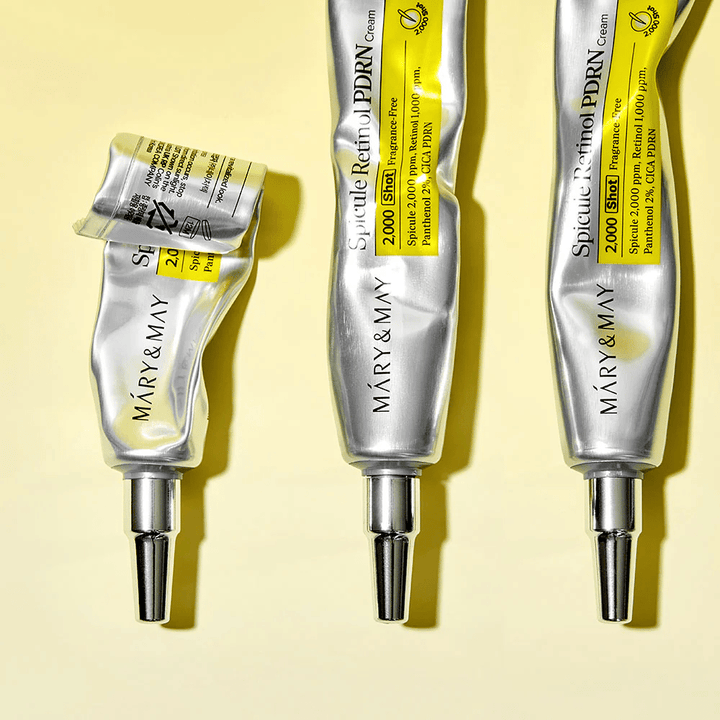 MARY & MAY Spicule Retinol PDRN Cream z vidno uporabo v tubi, prikazuje konsistenco kreme in usmerjen aplikator za natančno nanašanje na kožo.
