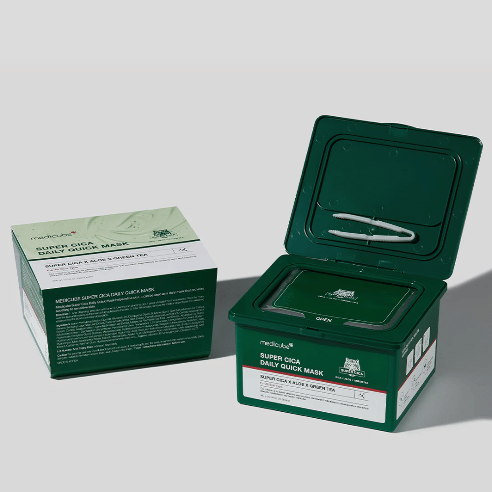 Dva paketa medicube Super Cica Daily Quick Mask – ena zaprta škatla in ena odprta zelena plastična posoda s pinceto v pokrovu. Maske vsebujejo Cico, alojo in zeleni čaj za dnevno nego in pomirjujoč učinek.