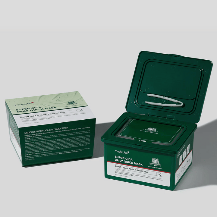 Dva paketa medicube Super Cica Daily Quick Mask – ena zaprta škatla in ena odprta zelena plastična posoda s pinceto v pokrovu. Maske vsebujejo Cico, alojo in zeleni čaj za dnevno nego in pomirjujoč učinek.