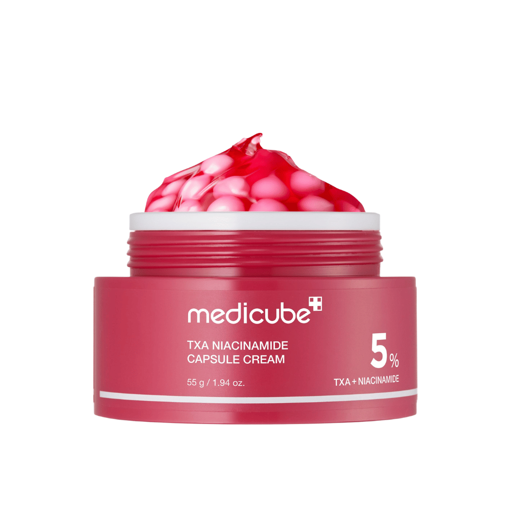 Medicube TXA Niacinamide Capsule Cream v lončku z rožnatimi kapsulami v obliki gela, z jasno označbo izdelka s 5 % TXA + Niacinamide.