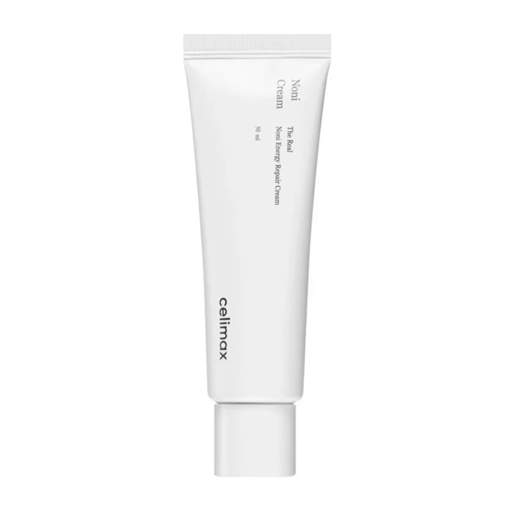 Celimax Noni Energy Repair Cream v beli tubi s črnim besedilom. Izdelek je označen kot "The Real Noni Energy Repair Cream" in ima prostornino 50 ml.