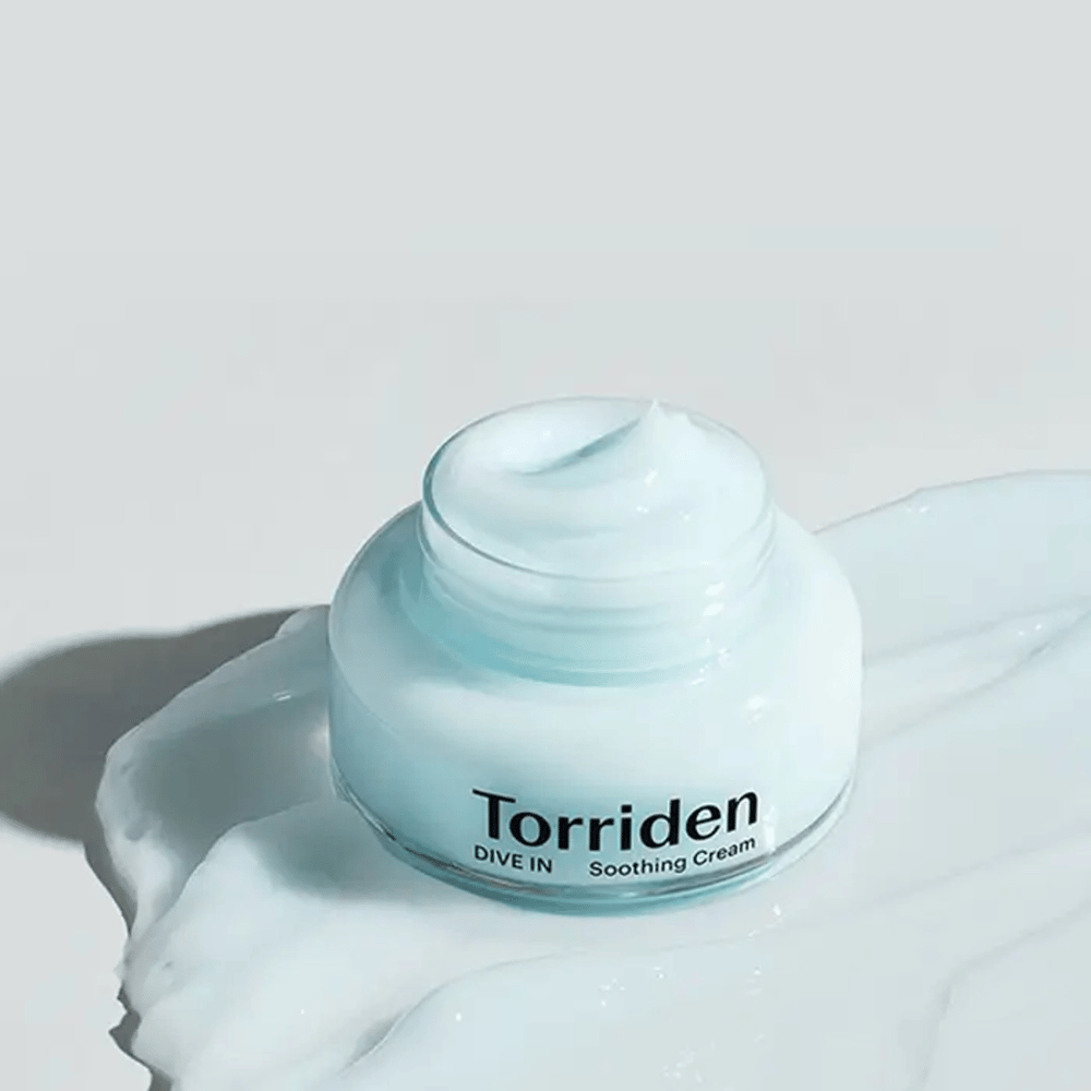 Torriden DIVE-IN Low Molecular Hyaluronic Acid Soothing Cream 100ml zagotavlja dolgotrajno vlaženje na beli površini.