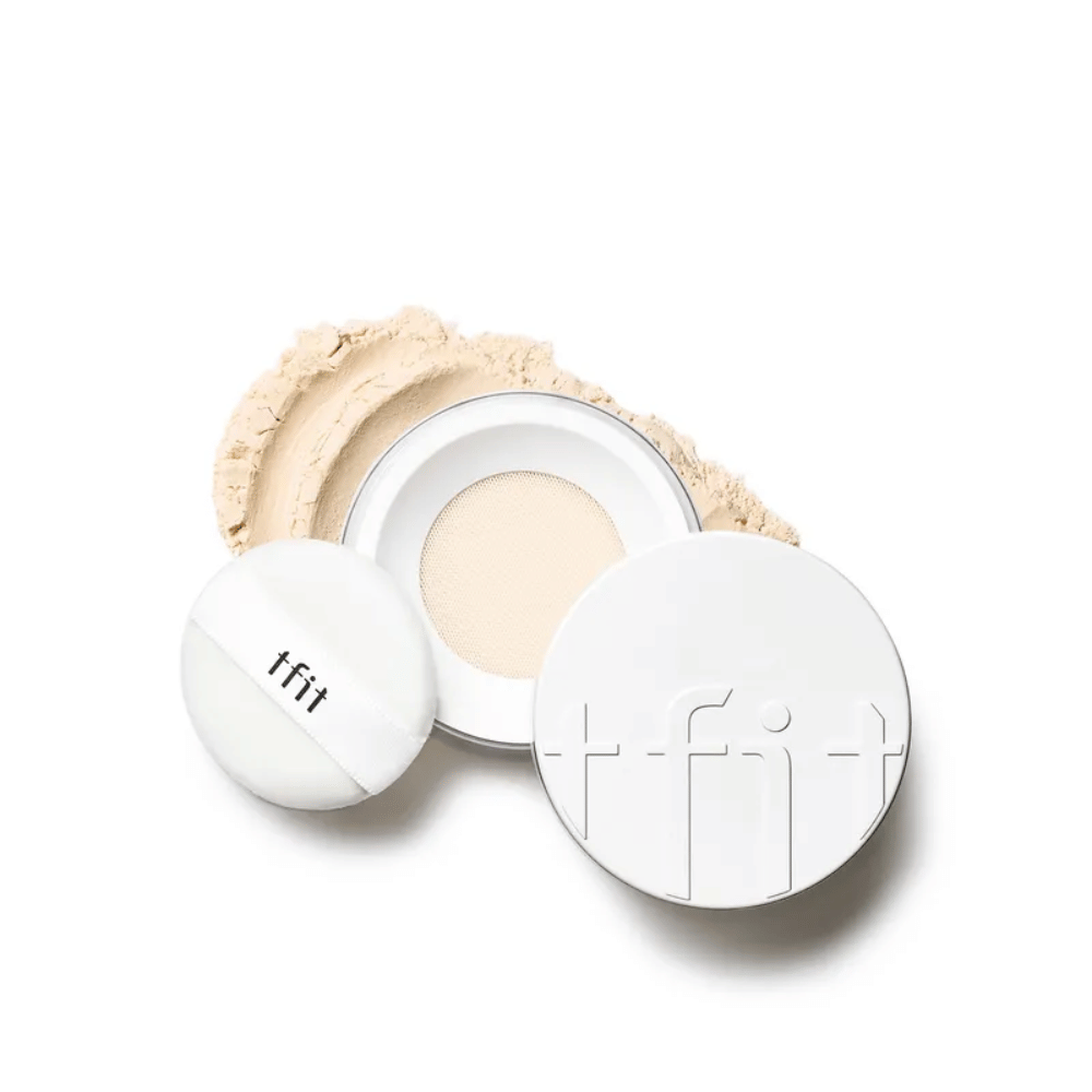 Odprta škatlica s TFIT Translucent Set Finishing Powder v odtenku Skin Beige, s priloženim puffom in raztresenim pudrom okoli.