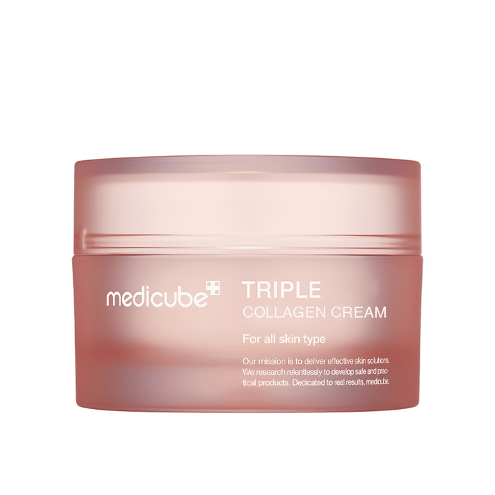 Slika prikazuje posodo kreme Medicube Triple Collagen Cream. Ta krema za obraz je zasnovana za vse tipe kože in obljublja izboljšanje elastičnosti kože in ravni vlažnosti. Dizajn je minimalističen z mehko rožnato barvo na embalaži.