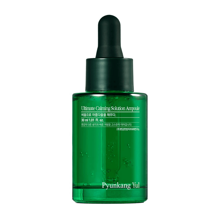 Slika prikazuje steklenico Pyunkang Yul Ultimate Calming Solution Ampoule. Steklenica je prozorna z zelenim odtenkom in ima črn kapalni pokrov. Izdelek izgleda kot serum za nego kože, namenjen pomirjanju kože.