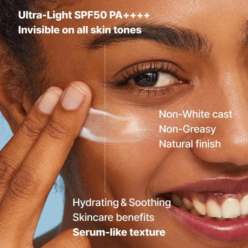Povečava ženske, ki s prsti nanaša prozorno kremo za sončenje; besedilo poudarja SPF50 PA++++, brez belega filma, naravni zaključek in serumsko podobno vlažilno teksturo.