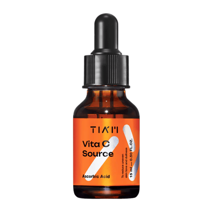 TIA'M Vita C Source, serum z askorbinsko kislino v rjavi steklenički s črno pipeto in oranžno etiketo – učinkovito za posvetlitev kože in zmanjšanje neenakomernega tena kože.