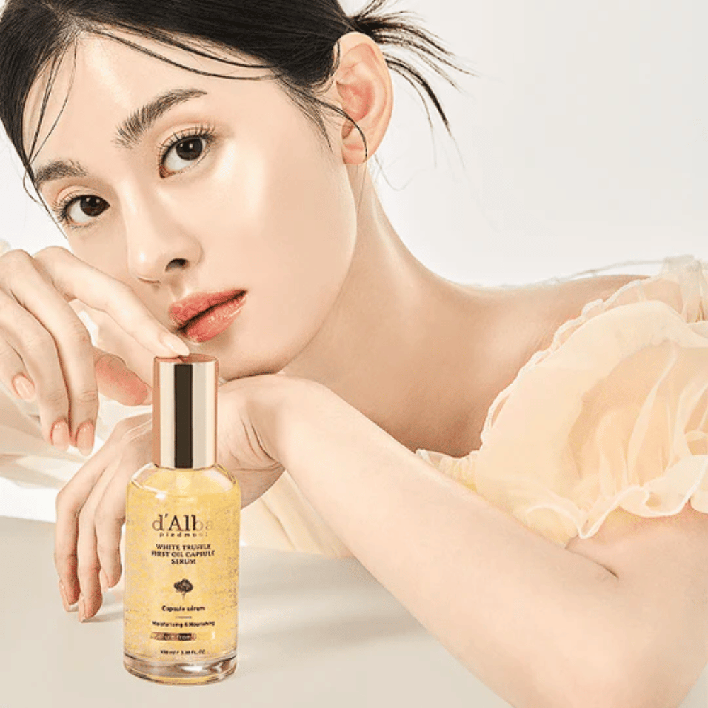 Model z žarečo kožo pozira poleg d'Alba White Truffle First Oil Capsule Serum.