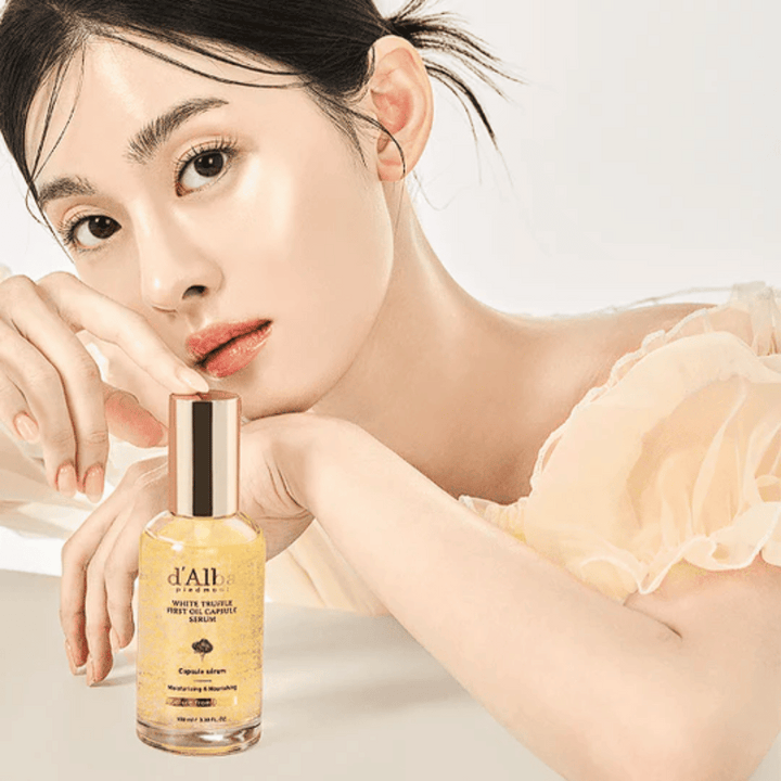 Model z žarečo kožo pozira poleg d'Alba White Truffle First Oil Capsule Serum.
