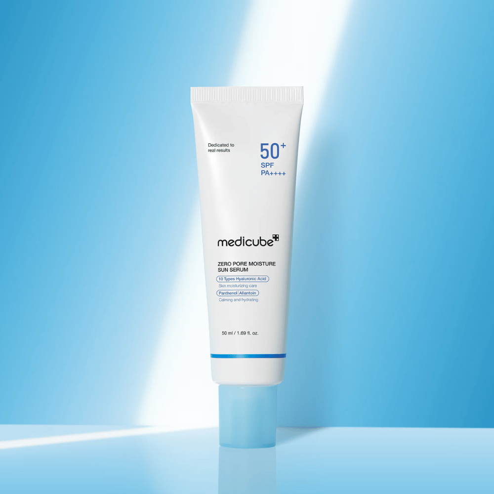 Medicube Zero Pore Moisture Sun Serum SPF50+ PA++++ predstavljeno na modrem ozadju. Vlažilni sončni serum s hialuronsko kislino, pantenolom in alantoinom za vsakodnevno UV-zaščito in nego kože.