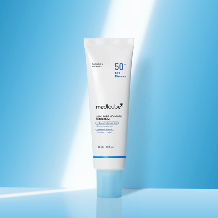 Medicube Zero Pore Moisture Sun Serum SPF50+ PA++++ predstavljeno na modrem ozadju. Vlažilni sončni serum s hialuronsko kislino, pantenolom in alantoinom za vsakodnevno UV-zaščito in nego kože.