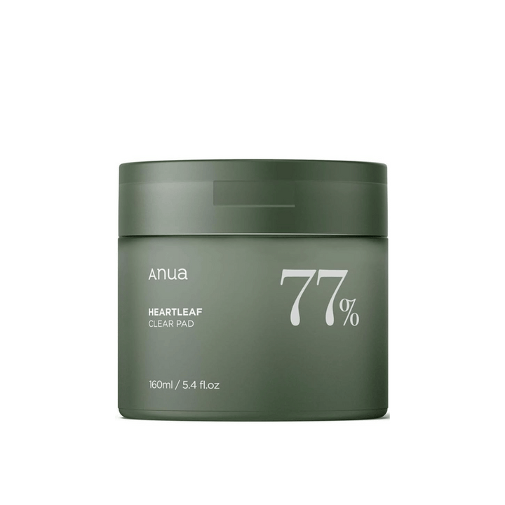 Zelena posoda z izdelkom za nego kože Anua Heartleaf Clear Pad, ki poudarja 77% na etiketi, proti enobarvnemu ozadju.