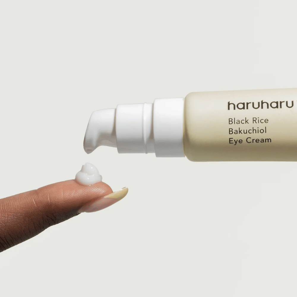 HaruHaru Wonder Black Rice Bakuchiol Eye Cream – bližnji posnetek črpalke, ki iztisne kremo na konico prsta, prikazuje teksturo za vlaženje in proti staranju.
