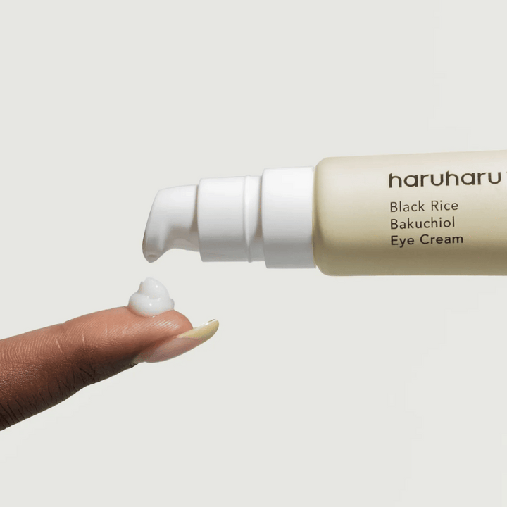 HaruHaru Wonder Black Rice Bakuchiol Eye Cream – bližnji posnetek črpalke, ki iztisne kremo na konico prsta, prikazuje teksturo za vlaženje in proti staranju.