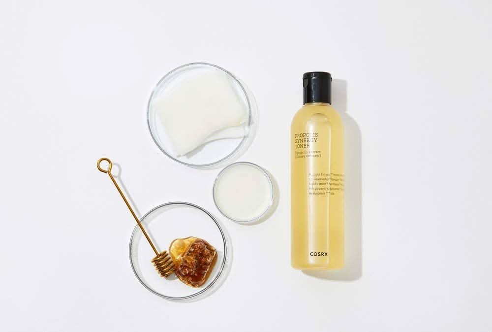 Steklenica COSRX Full Fit Propolis Synergy Toner 150ml z protivnetnimi in antibakterijskimi učinki, postavljena na belo površino.