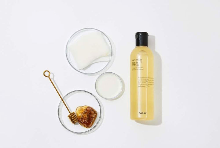 Steklenica COSRX Full Fit Propolis Synergy Toner 150ml z protivnetnimi in antibakterijskimi učinki, postavljena na belo površino.