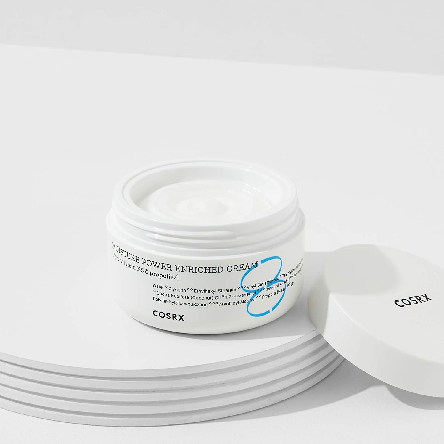 Kozarec COSRX Moisture Power Enriched Cream 50ml, ki stoji na mizi.