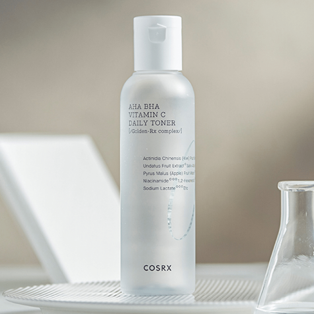 Steklenička COSRX Refresh AHA BHA Vitamin C Daily Toner 150ml, ki stoji na beli plošči.