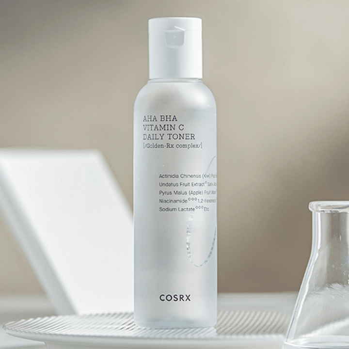 Steklenička COSRX Refresh AHA BHA Vitamin C Daily Toner 150ml, ki stoji na beli plošči.