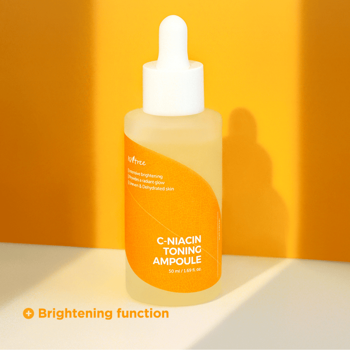 Steklenička Isntree C-Niacin Toning Ampoule 50ml z osvetlitvenimi lastnostmi ampule na rumeni podlagi.